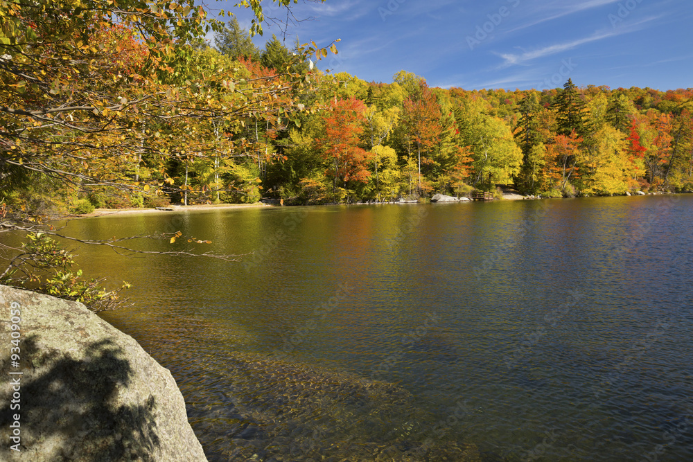Colorful shoreline of Russell Pond in autumn, New Hampshire.