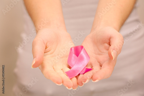 Female hands holding pink ribbon sign, closeup