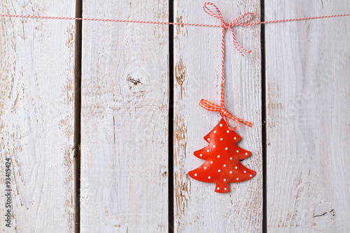 Christmas tree ornament hanging over white wooden background
