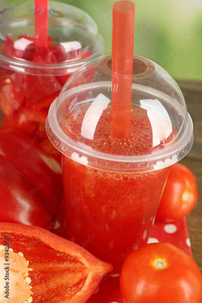 Red vegetable and fruit salad and healthy fresh drink in plastic cups on wooden background. Colorful diet concept Red vegetable and fruit salad and healthy fresh drink in plastic cups on wooden background. Colorful diet concept