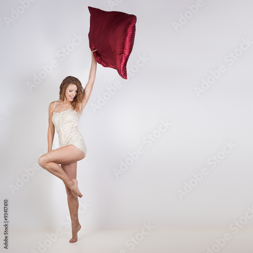 pretty vigorous athletic cheerful girl in pajamas kravivoy bright sing and rejoice after sleeping , playing with a pillow photo