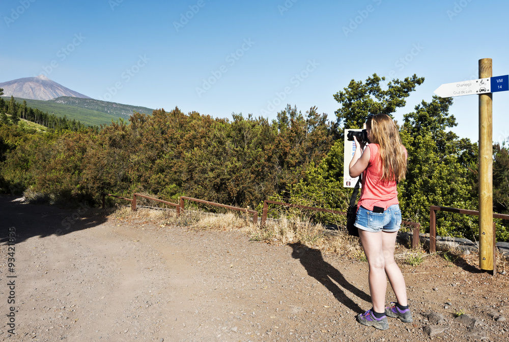 Naklejka premium Young girl taking photo in Teide national Park