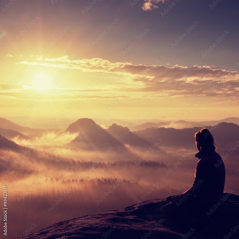 Beautiful  young long hair girl tourist enjoy daybreak on the sharp corner of sandstone rock and watch over valley to Sun.