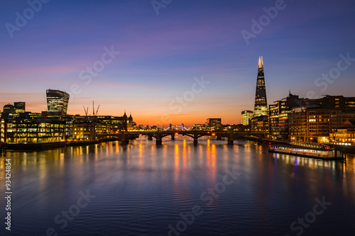 London cityscape during sunrise - river Thames with silhouettes of modern skyscrapers