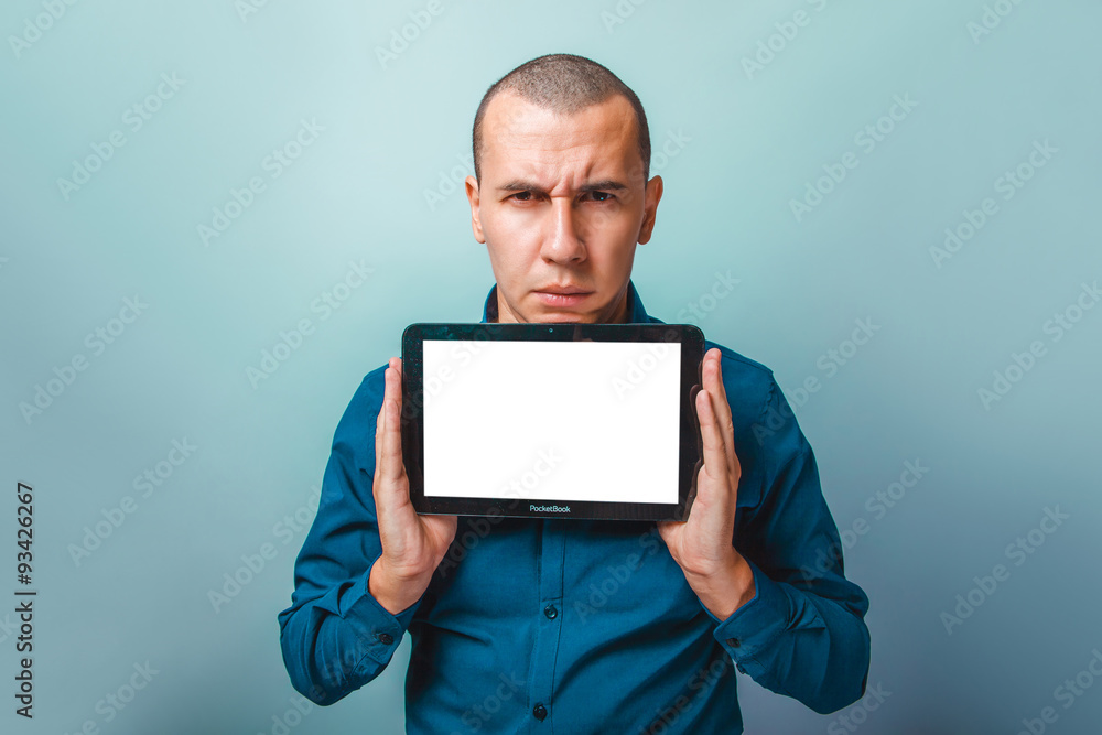 a man of European appearance thirty years, holding a tablet frow