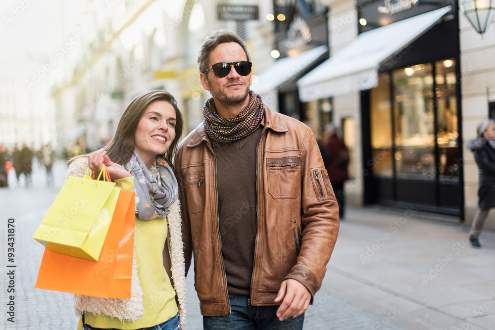 Stylish couple walking in a cobbled car-free street. Stylish couple walking in a cobbled car-free street.