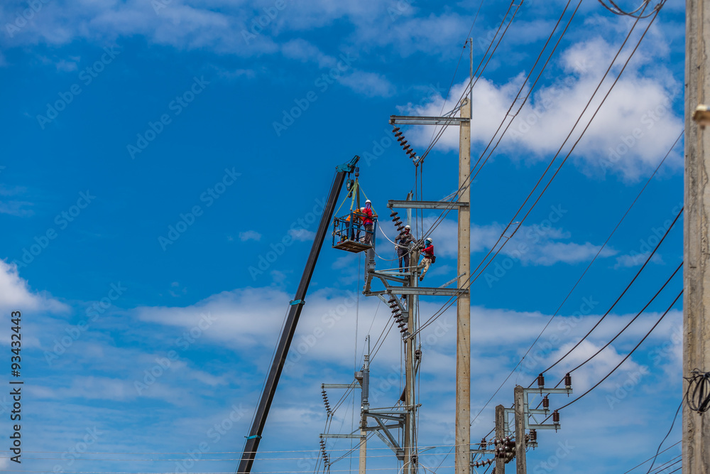 Electrician stays on the tower pole and repairs a wire of the po