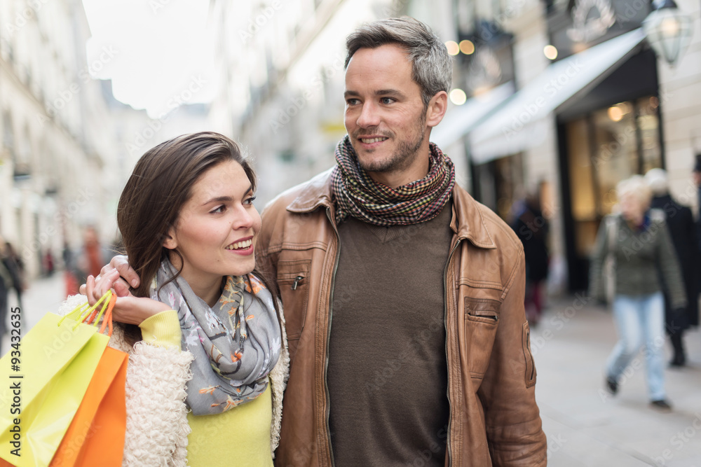 Stylish couple walking in a cobbled car-free street, shopped Stylish couple walking in a cobbled car-free street, shopped