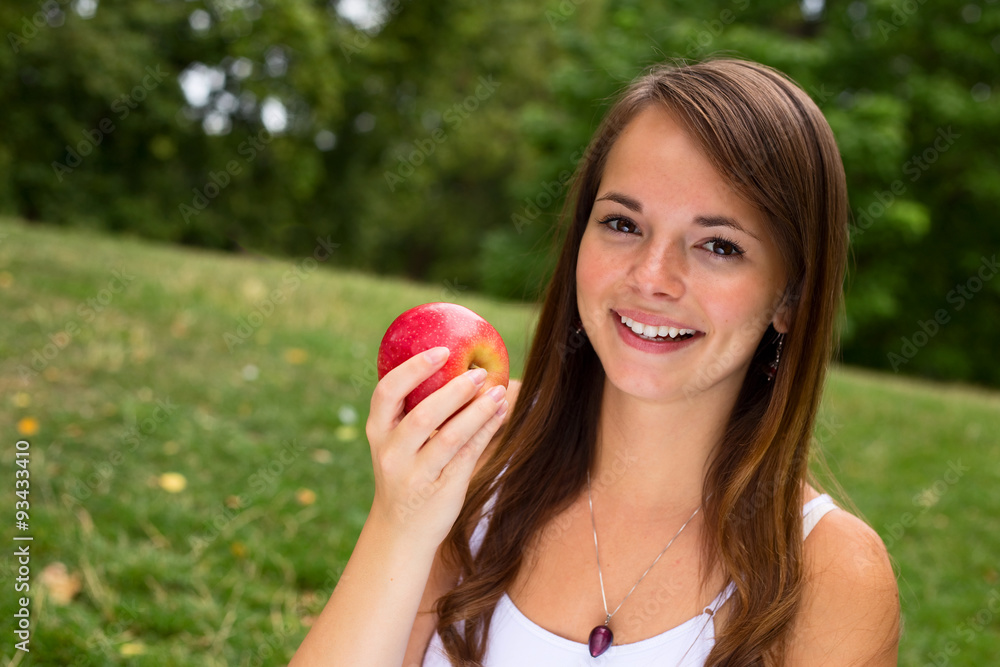 young woman smiling holding an apple young woman smiling holding an apple