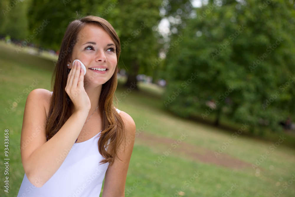 young woman cleaning her face with cotton face pads young woman cleaning her face with cotton face pads
