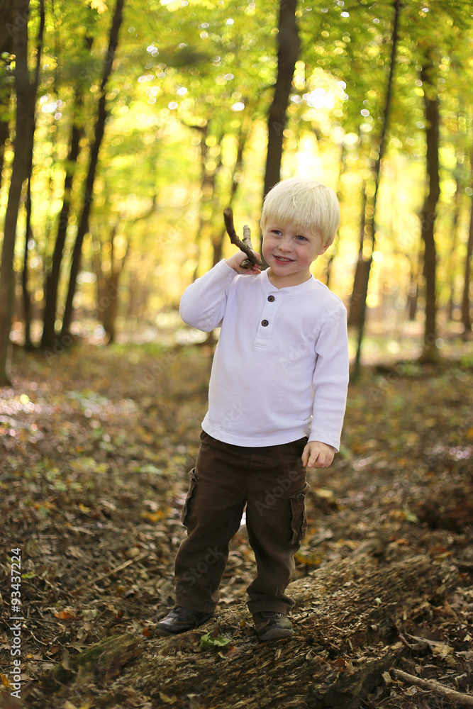 Young Child Playing with Stick in Autumn Forest Young Child Playing with Stick in Autumn Forest