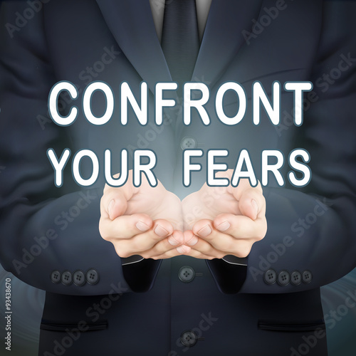 businessman holding confront your fears words