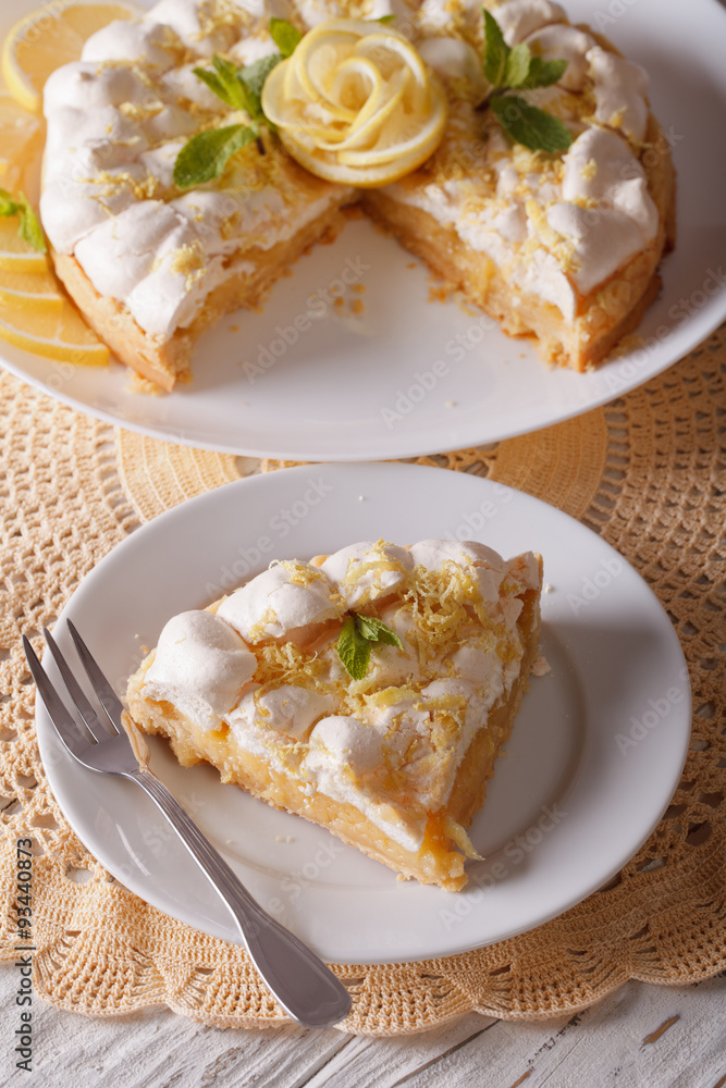 Delicious sliced lemon meringue cake close up on the table. vertical
Delicious sliced lemon meringue cake close up on the table. vertical
