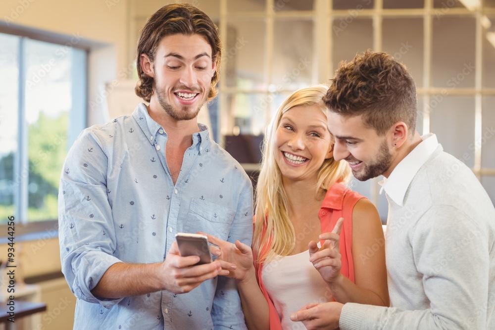Businessman showing something on smart phone to colleagues Businessman showing something on smart phone to colleagues