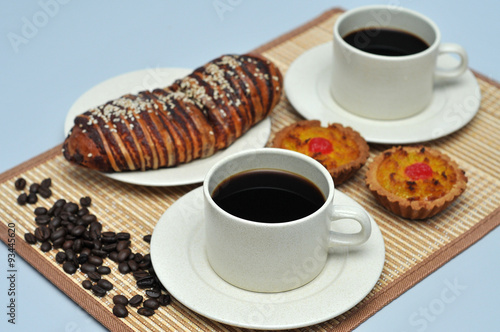 hot coffee with coconut tart and red bean bread on bamboo mat