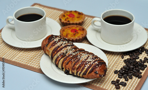 hot coffee with coconut tart and red bean bread on bamboo mat