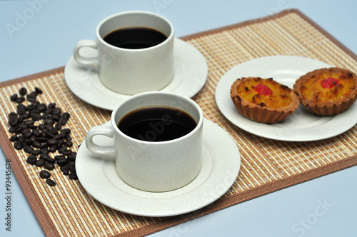 hot coffee with coconut tart on bamboo mat