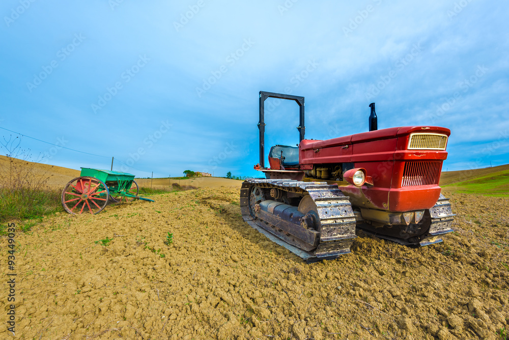 Fototapeta premium Red tractor on caterpillars on the autumn fields