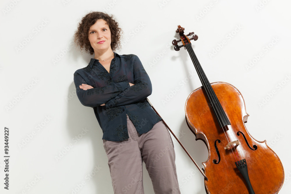 Portrait of young cellist. Portrait of young cellist. She stands next to her instrument Portrait of young cellist. Portrait of young cellist. She stands next to her instrument