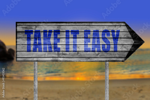 Take It Easy wooden sign with on a beach background