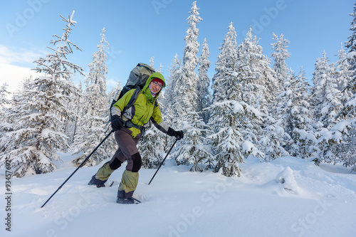 Backpacker woman is walking in forest in wintertime
