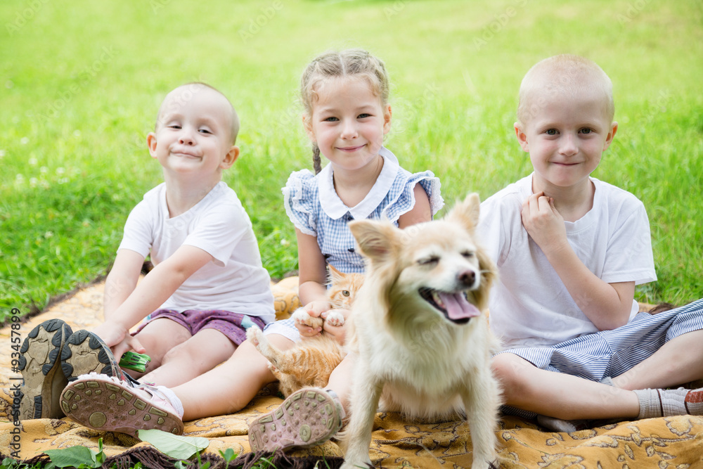 Sister with brothers playing with a cat and a dog Sister with brothers playing with a cat and a dog
