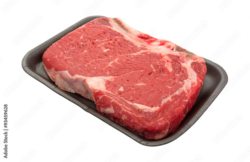 Bone in rib eye steak on black butcher tray