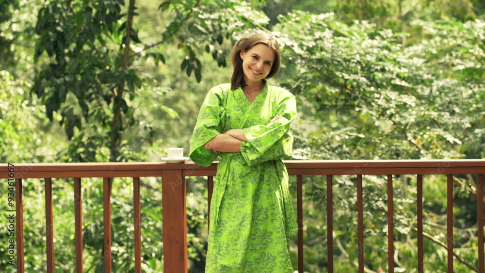 Portrait of happy, young woman in bathrobe standing on terrace
Portrait of happy, young woman in bathrobe standing on terrace