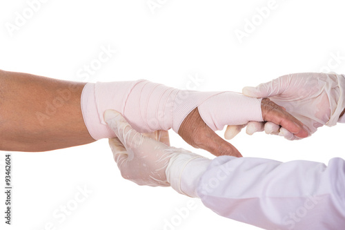 Close-up female doctor is bandaging hand of patient