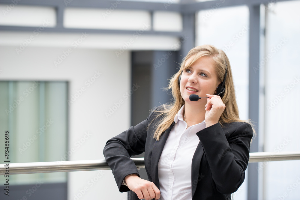 Businesswoman working & sitting at her desk in an office Businesswoman working & sitting at her desk in an office
