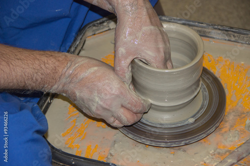 Potter makes on the pottery wheel clay jug. The hands of a potte