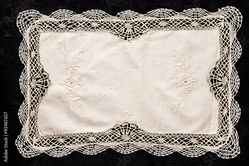 Old vintage napkin with lace border on the black wooden table