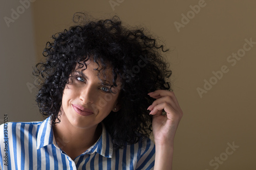 Portrait of attractive young woman with curly black hair