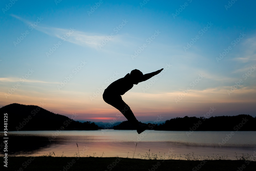 Fototapeta premium Silhouettes jumping on reservoir at sunset.