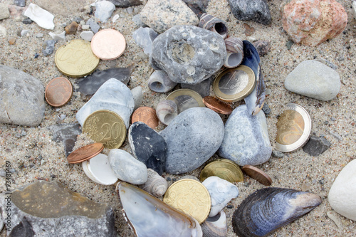 gold coins   Coins  stones and shells in the sand