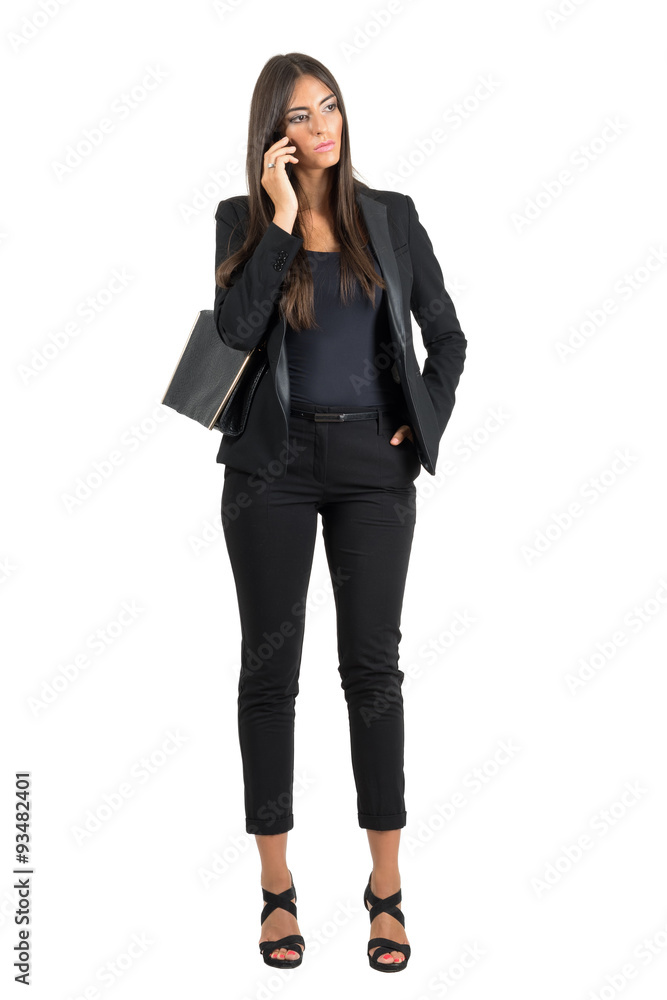 Fototapeta premium Serious worried business woman in suit talking on the mobile phone looking down