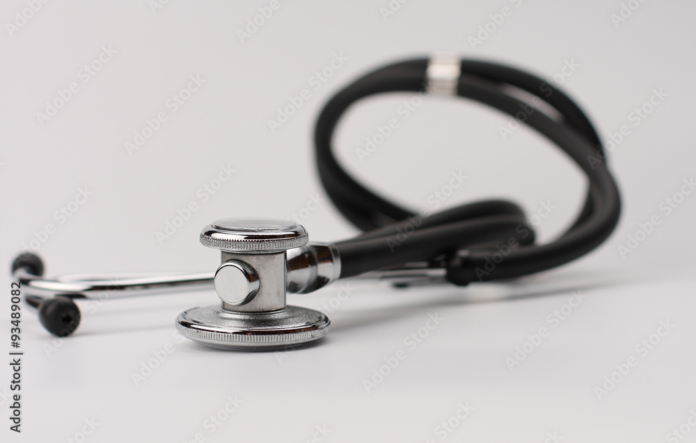 Black stethoscope on white background, close up view. Black stethoscope on white background, close up view.