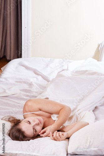 Portrait of the beautiful young woman sleeping in white bed