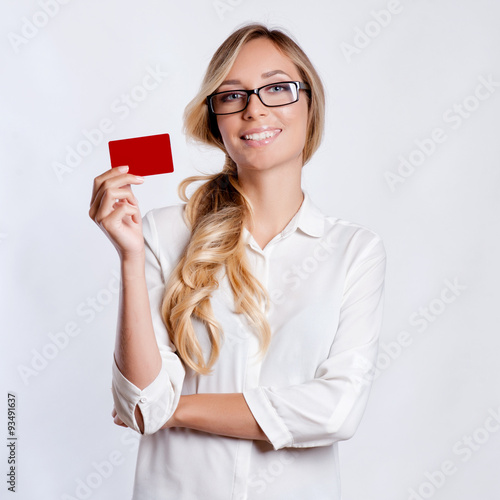 Close-up portrait of young smiling business woman holding credit card isolated on white background