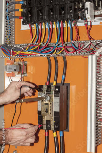 electrical engineer testing a circuit breaker in a control panel