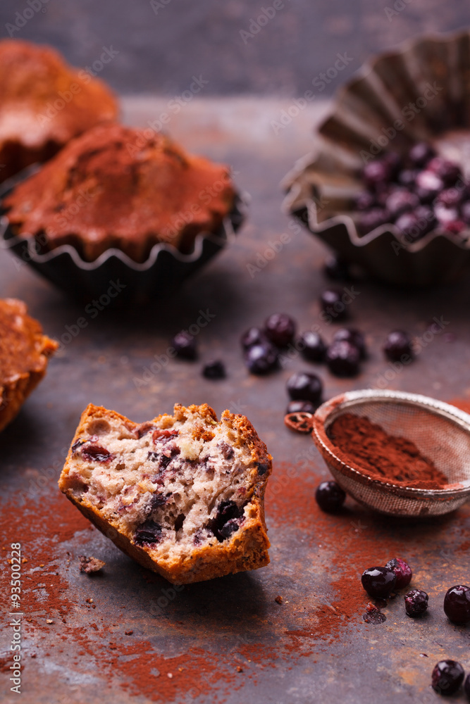 Muffins with blueberries, topped with cocoa powder, on a dark background.selective focus.