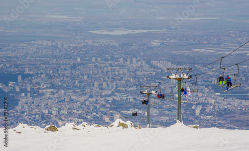 skilift is bringing skiers to the top of vitosha mountain in bulgaria. capital of the country sofia is on background. photo