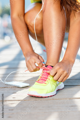 Running shoes - woman tying shoe laces. Closeup of female sport