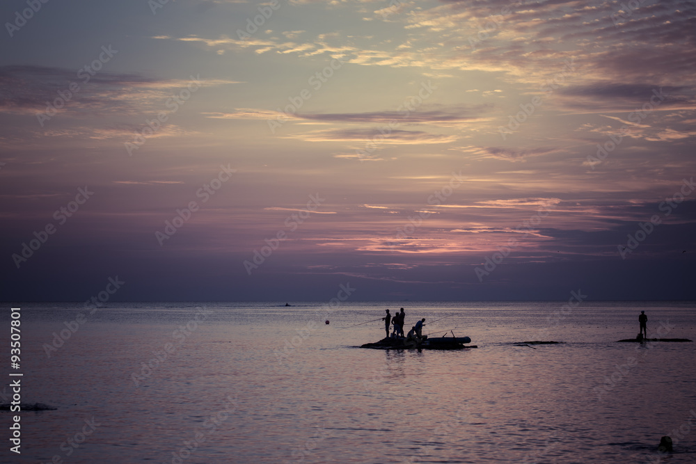 Ocean landscape at sunset. Silhouettes of fishermen. Ocean landscape at sunset. Silhouettes of fishermen.