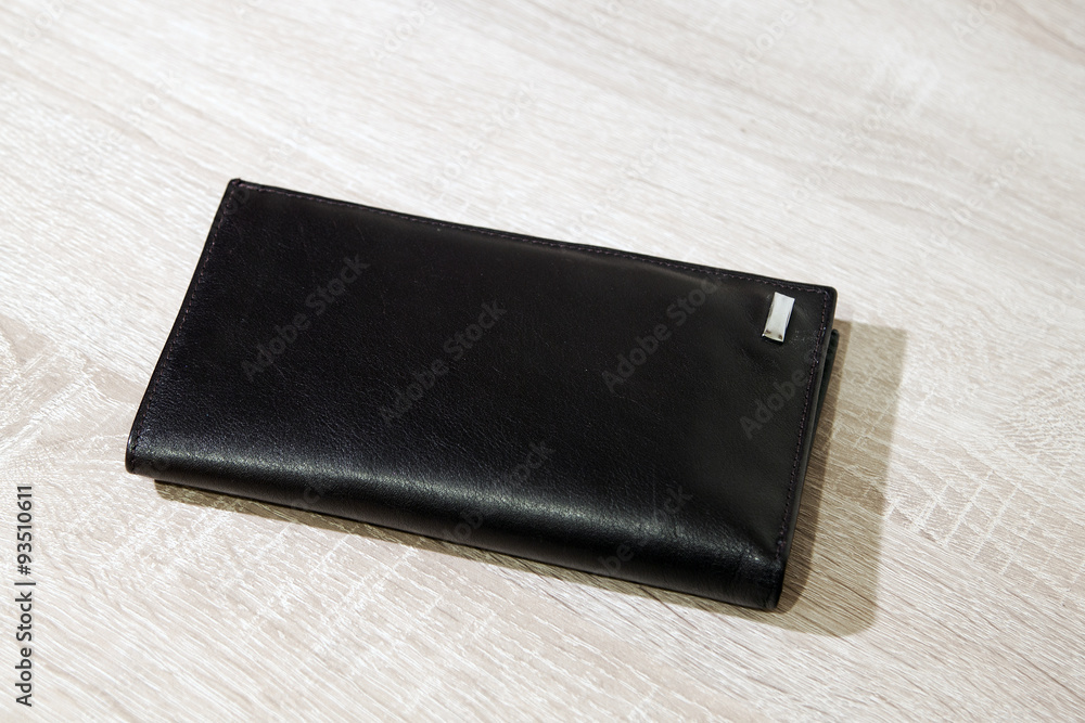 Brown leather wallet on wooden desk background Brown leather wallet on wooden desk background