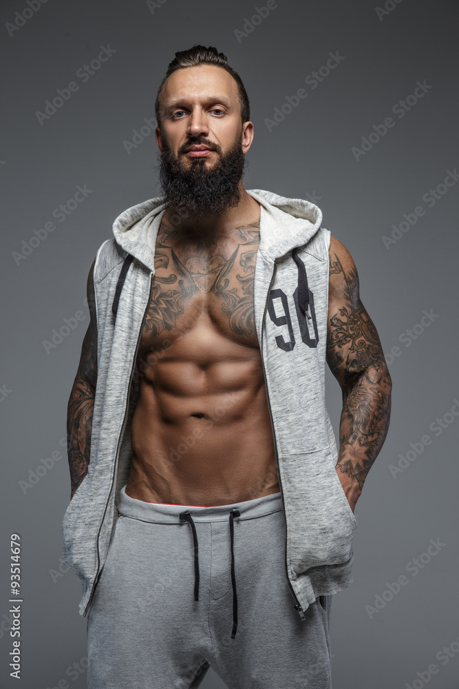 Muscular tattooed man with beard.