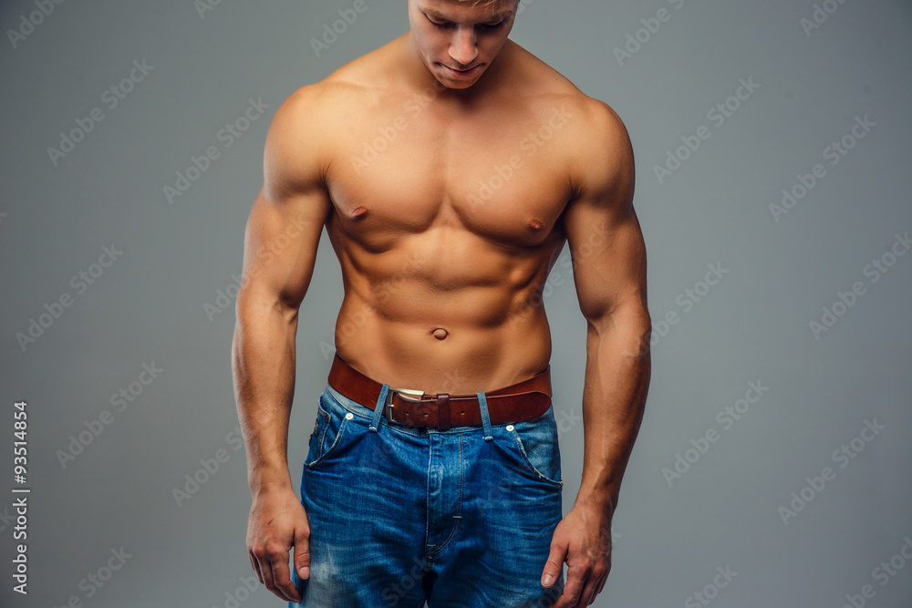 Young bodybuilder in denim jeans.