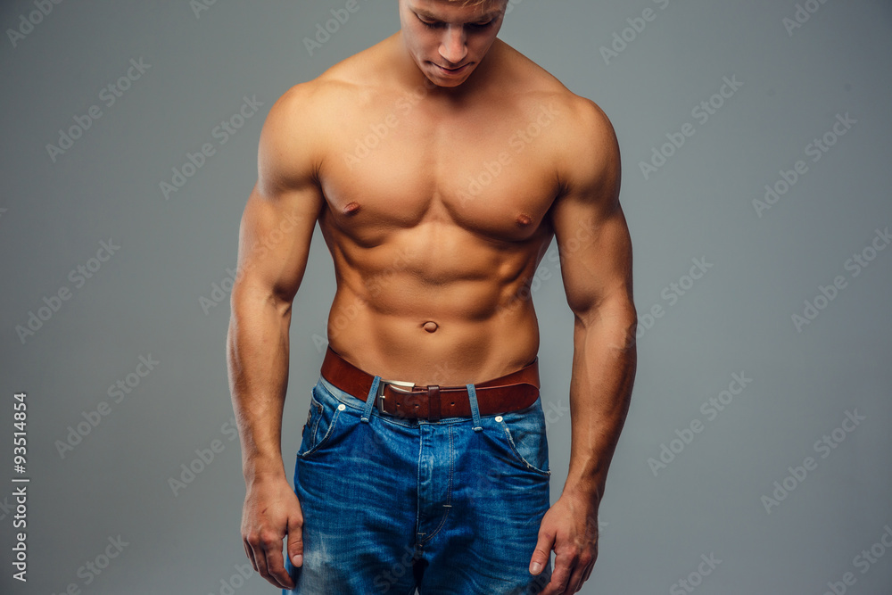 Fototapeta premium Young bodybuilder in denim jeans.