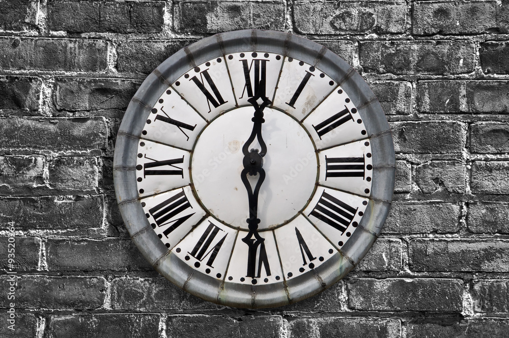 Vintage retro style clock on a brick wal, black and white