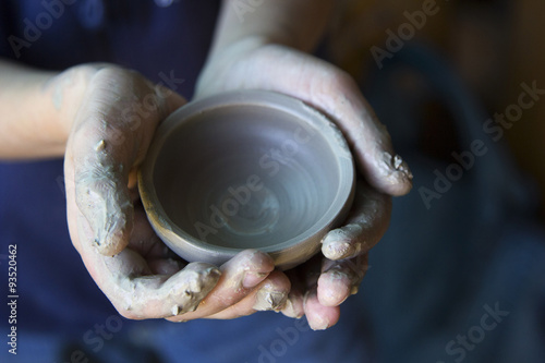 close up photo of childish hands with potter clay vase